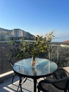 Paradise Apartments Becici في بيشيشي: طاولة عليها نبات فوق شرفة