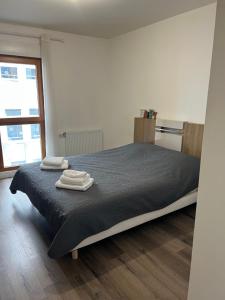 1 dormitorio con 1 cama con 2 toallas en Appartement 2 pièces ligne 1, en Montreuil