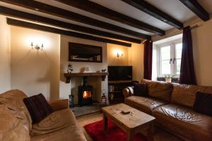 a living room with a couch and a fireplace at Dale End Cottage, Brassington in Brassington