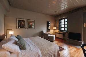 a bedroom with a bed and a flat screen tv at Aristi Mountain Resort in Aristi