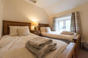 a bedroom with two beds and a window at Dale End Cottage, Brassington in Brassington