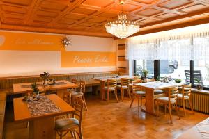 a restaurant with tables and chairs and a chandelier at Pension Erika in Mehlmeisel