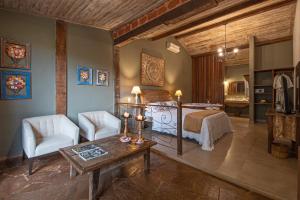 Un dormitorio con una cama y una mesa y sillas. en Brisa da Serra Pousada Boutique, en Tiradentes