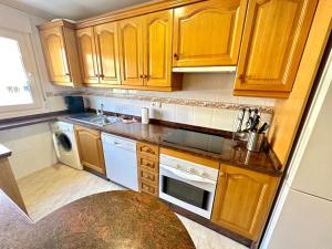 a kitchen with wooden cabinets and a stove top oven at Bonito piso 2 bed 2 bath El Drac in El Campello +9 photos