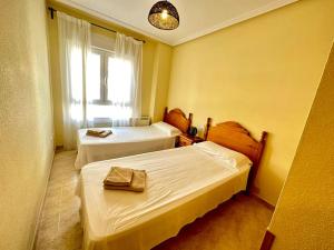a hotel room with two beds and a window at Bonito piso 2 bed 2 bath El Drac in El Campello