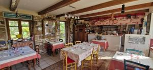 un restaurante con mesas y sillas y una cocina en Auberge De Bel Air en Brélès