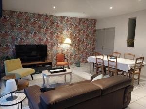 a living room with a couch and a dining room at La Maison de Léonie in Péronne