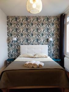 a bedroom with a bed with two rolled towels on it at La Maison de Léonie in Péronne +5 photos