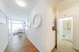 a hallway with white walls and a mirror on a wall at Central Apartment Lofts in Vienna