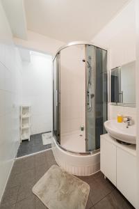 a white bathroom with a sink and a shower at Central Apartment Lofts in Vienna