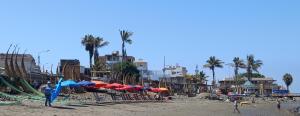 una spiaggia con ombrelloni e persone sulla spiaggia di Bellos Dptos Huanchaco, Perú a 50 metros del mar a Trujillo