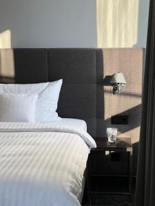 a bedroom with a bed and a table with a lamp at AvidonApartments in Düsseldorf