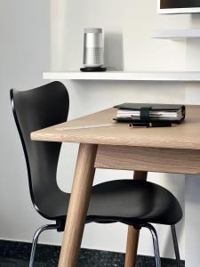 einen Schreibtisch mit einem schwarzen Stuhl und einem Holztisch in der Unterkunft AvidonApartments in Düsseldorf
