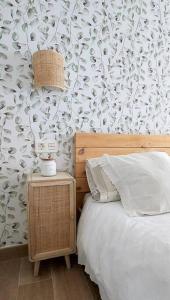 1 dormitorio con cama y papel pintado con motivos florales en Piso con encanto en pleno centro, en Oviedo