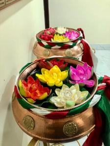 trzy miski wypełnione różnymi kolorowymi kwiatami na stole w obiekcie ALL SEASONS HOTEL w mieście Gangtok
