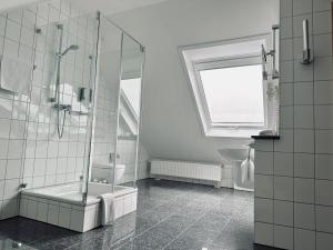 a bathroom with a shower and a tub and a sink at AvidonApartments in Düsseldorf