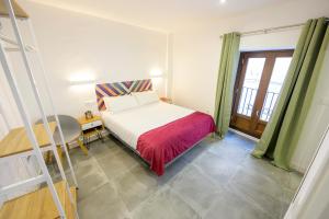 1 dormitorio con cama, mesa y escalera en Hospedería La casa del Alarife en Úbeda