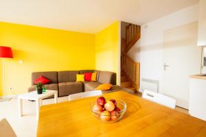 a living room with a bowl of fruit on a table at Résidence L'Oustal Del Carlat in Carla-Bayle