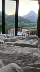 two beds in a room with a view of a mountain at Best view Kazbegi in Kazbegi