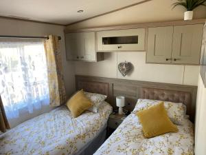 Habitación pequeña con 2 camas y ventana en Luxury Lake District Holiday Home-Sleeps 4, en Cockermouth