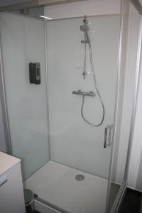 um chuveiro com uma porta de vidro na casa de banho em Le P'tit Bouchon em Rambervillers