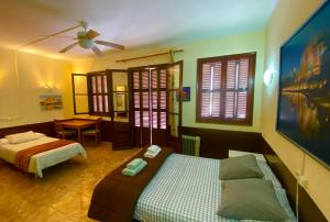 a bedroom with two beds and a ceiling fan at Hostal Atlanta in El Arenal