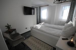 a small bedroom with a bed and a chair at Apartment Francesca mit Parkplatz nähe Altstadt in Sibiu
