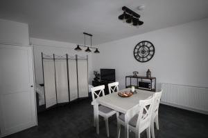 a dining room with a table and chairs and a clock at Apartment Francesca mit Parkplatz nähe Altstadt in Sibiu