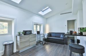 ein Wohnzimmer mit einem Sofa und einem TV in der Unterkunft Suite Tropez, Résidence de prestige in La Croix-Valmer