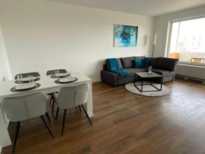 a living room with a table and a couch at SUITE4ME - Moderne Ferienwohnung I Küche I Balkon I Mainz-Kostheim in Wiesbaden