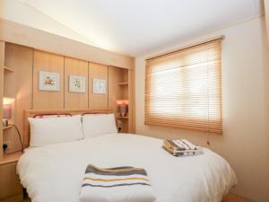 a bedroom with a large white bed with a window at The Hideaway in Weymouth