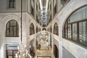 an empty hallway in a building with chandeliers at Legacy Ottoman Hotel in Istanbul