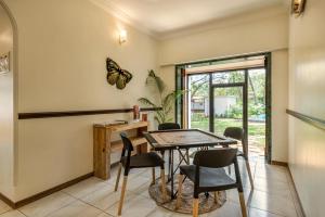 阿利鲍格SaffronStays Gaia - 4BR pool villa with yoga sessions, coconut lawns & Mandwa Jetty access的餐厅墙上挂着一只蝴蝶。