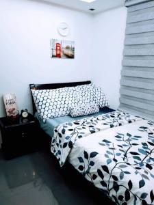 a bedroom with a bed with a black and white comforter at ADB Tower 1 bedroom with fast wifi and Netflix at Ortigas across Robinson's Galleria in Manila