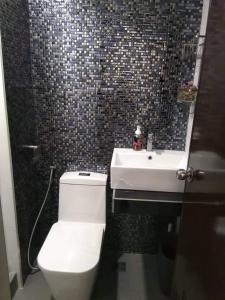 a bathroom with a white toilet and a sink at ADB Tower 1 bedroom with fast wifi and Netflix at Ortigas across Robinson's Galleria in Manila