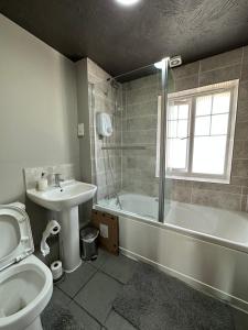 a bathroom with a sink and a tub and a toilet at Orchard House - Great Design, Comfortable furnitures, Free Wifi & Free Parking, Nice tidy Garden in Swindon