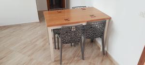 mesa con 2 sillas y mesa de madera en El Refugio, en Tetuán