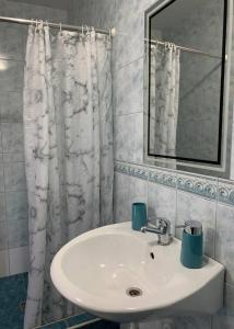 een badkamer met een wastafel en een spiegel bij Pension Sara in Hevlín