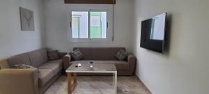 sala de estar con sofá y mesa en El Refugio en Tetuán