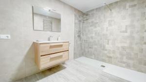 Un baño con lavabo y ducha con espejo. en Casa Pichusa, en Benicarló 7 fotos más