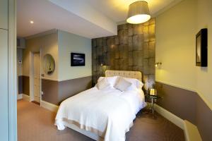 a bedroom with a bed with white blankets and pillows at 8 Beresford Street in Saint Helier Jersey