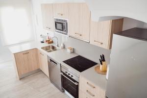 a small kitchen with a stove and a refrigerator at Casa Pichusa in Benicarló
