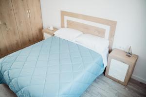 Un dormitorio con una gran cama azul y una mesa en Casa Pichusa, en Benicarló