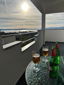 dwa kieliszki wina siedzące na stole na balkonie w obiekcie Apartment Marko with a beautiful view of the sea w mieście Kaštel Sućurac