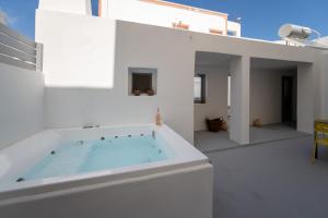 a bath tub sitting on top of a white house at Villa Tholos & Prive Jacuzzi in Kamari