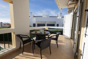 een patio met een tafel en stoelen op een balkon bij Casa Mateus in Alvor