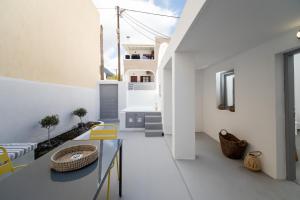 a living room with a glass table and yellow chairs at Villa Tholos & Prive Jacuzzi in Kamari