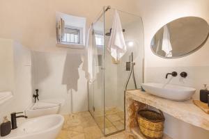 uma casa de banho com um lavatório, um WC e um espelho. em Masseria Macchia em Ceglie Messapica