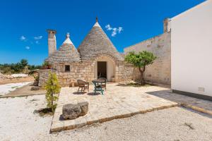a stone building with two chairs and a table at Masseria Macchia in Ceglie Messapica