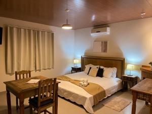 a bedroom with a bed with a teddy bear on it at Hotel Fazenda Minha Glória in Bom Jardim